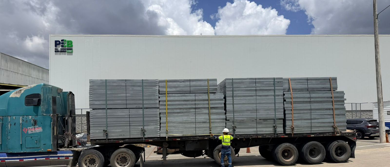 Camión cargado con paneles estructurales saliendo de la planta