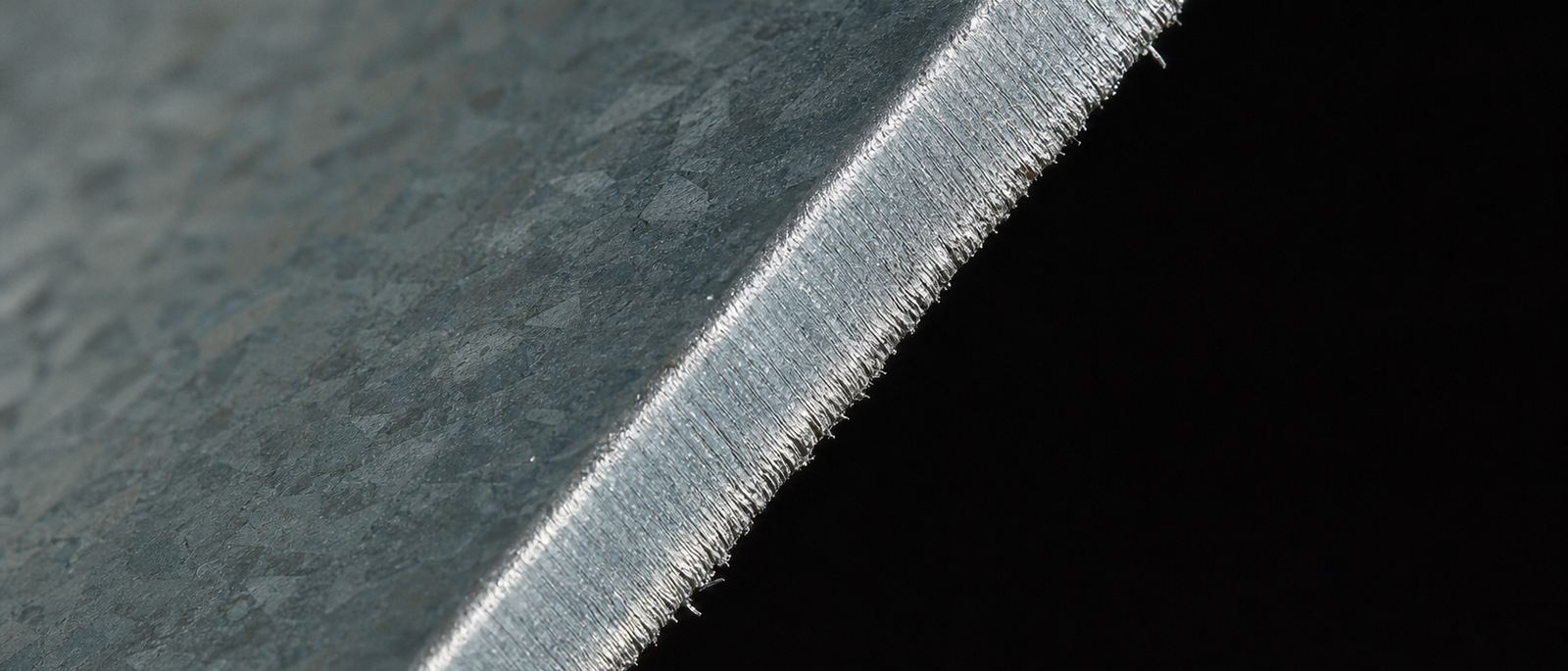 Macro del canto cortado de una lámina de acero con recubrimiento Zn-Al-Mg, con la escarcha del recubrimiento